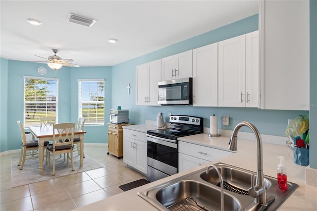 kitchen featuring visible vents, a sink, light countertops, appliances with stainless steel finishes, and white cabinetry