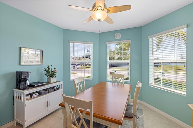 dining space with light tile patterned floors, baseboards, and a ceiling fan