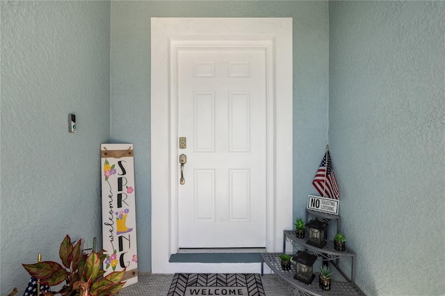 doorway to property featuring stucco siding