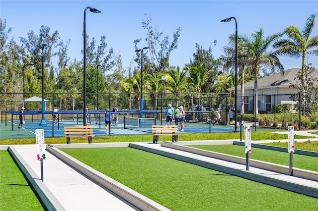 surrounding community with a tennis court and fence
