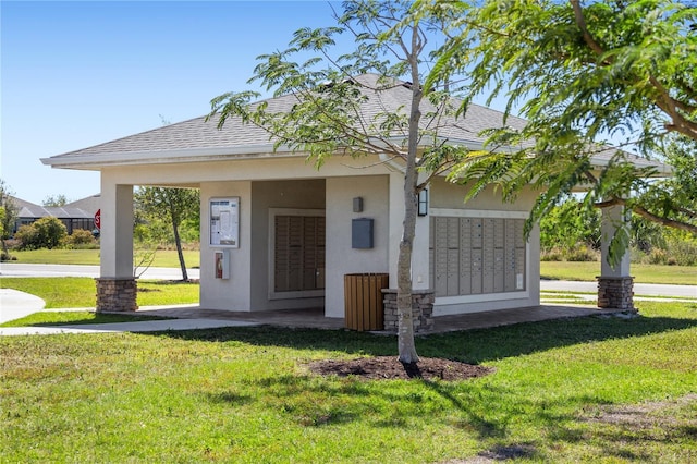 view of property's community with mail area and a yard