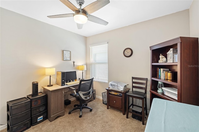 office area featuring light carpet, baseboards, and ceiling fan
