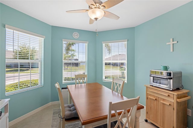 dining area with light tile patterned floors, ceiling fan, a toaster, and baseboards