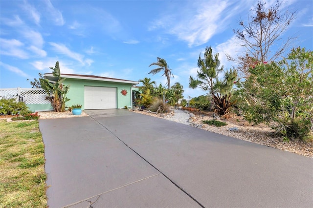 view of front of property featuring driveway, an attached garage, and stucco siding