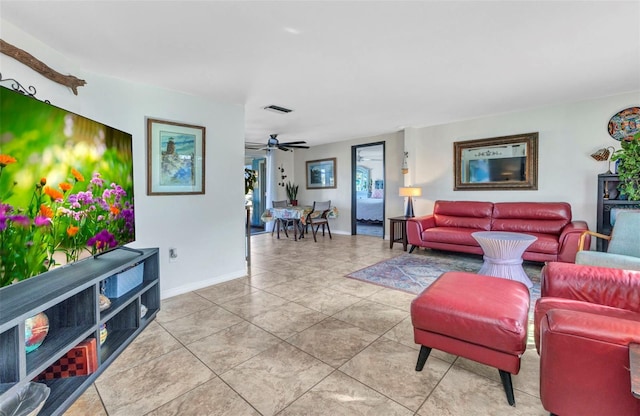 living room featuring baseboards, a ceiling fan, and light tile patterned flooring