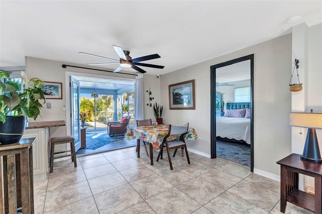 dining area with ceiling fan, baseboards, and light tile patterned floors