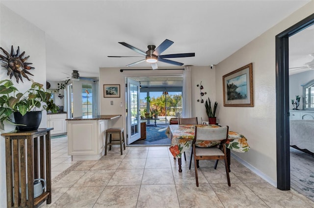 dining area featuring ceiling fan and baseboards