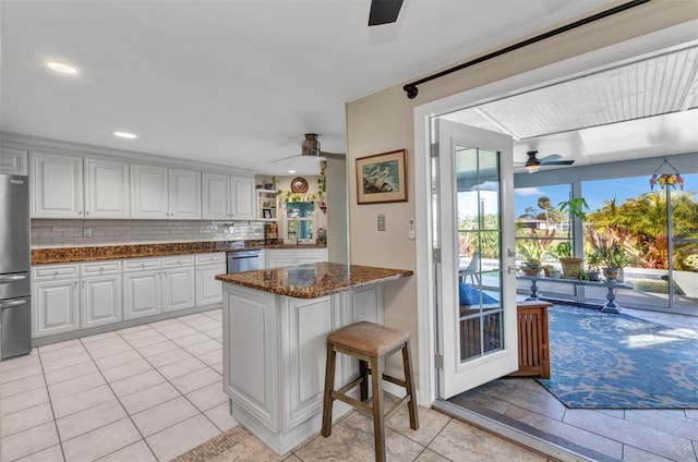 kitchen featuring ceiling fan, appliances with stainless steel finishes, white cabinets, dark stone countertops, and recessed lighting