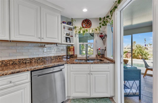 kitchen featuring stainless steel dishwasher, a sink, plenty of natural light, backsplash, and recessed lighting