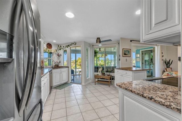 kitchen featuring appliances with stainless steel finishes, white cabinetry, light tile patterned floors, a sink, and recessed lighting