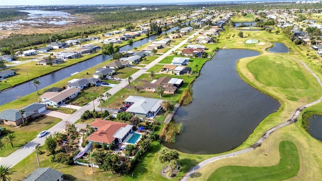 aerial view of property's location with nearby suburban area, a large body of water, and a local golf course