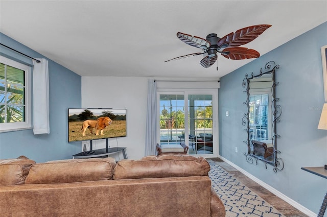 living area featuring ceiling fan and baseboards