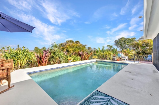 view of pool with a patio area and fence
