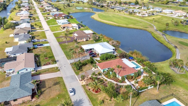 view of property location featuring nearby suburban area, a golf club, and a nearby body of water