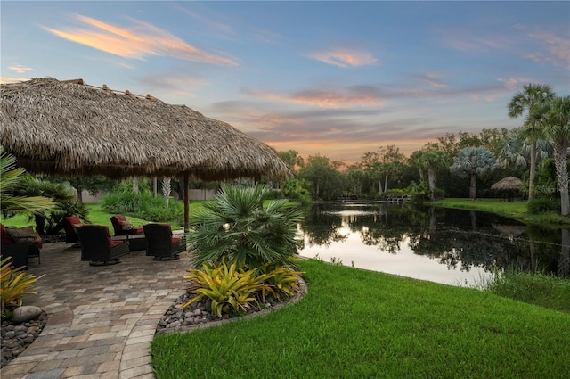 9990 SW Peace River St, Arcadia, FL 34269 - yard at dusk featuring a lawn, a patio, and a water view