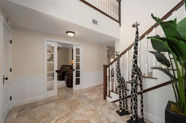 9990 SW Peace River St, Arcadia, FL 34269 - entrance foyer featuring a wainscoted wall, stairway, stone finish flooring, a chandelier, and a decorative wall