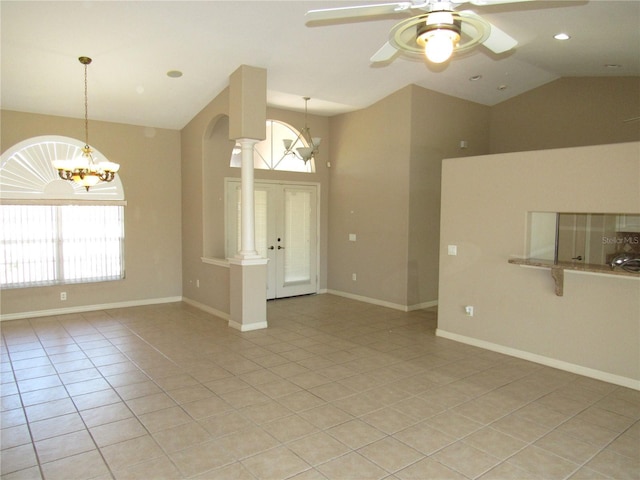unfurnished living room with light tile patterned flooring, baseboards, ceiling fan with notable chandelier, and plenty of natural light