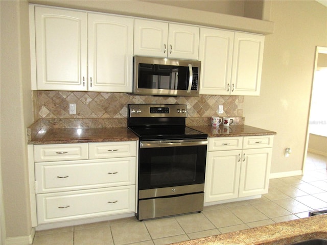 kitchen with decorative backsplash, white cabinets, light tile patterned floors, and appliances with stainless steel finishes