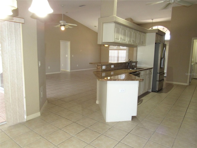 kitchen featuring light tile patterned floors, a peninsula, stainless steel refrigerator with ice dispenser, and a ceiling fan