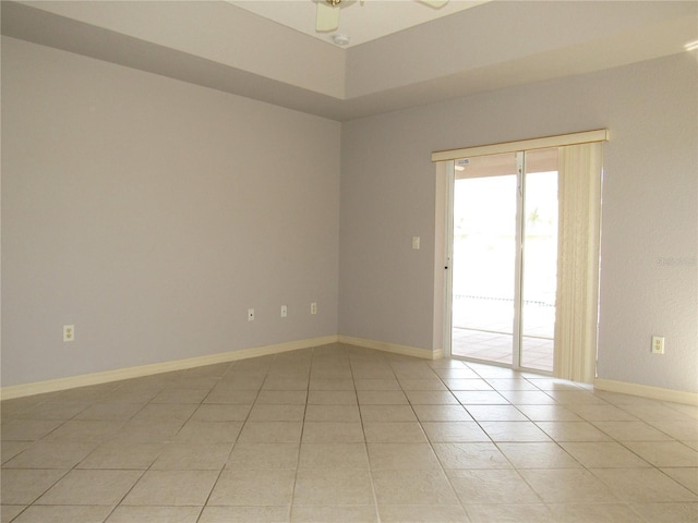 spare room with light tile patterned floors, baseboards, and a ceiling fan