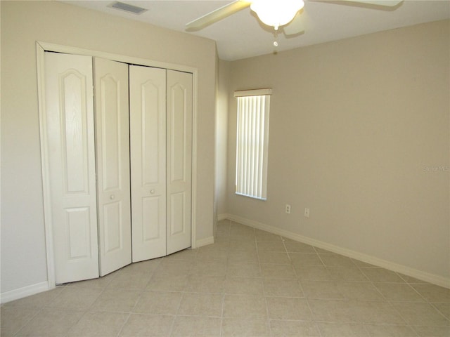 unfurnished bedroom featuring baseboards, light tile patterned flooring, ceiling fan, visible vents, and a closet