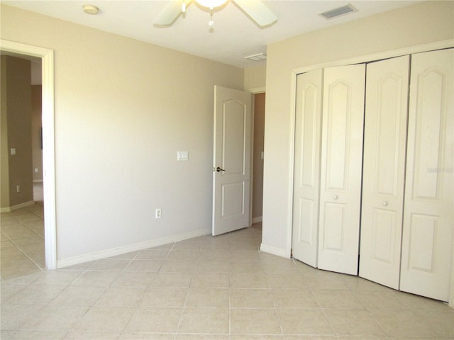 unfurnished bedroom with light tile patterned floors, baseboards, ceiling fan, visible vents, and a closet