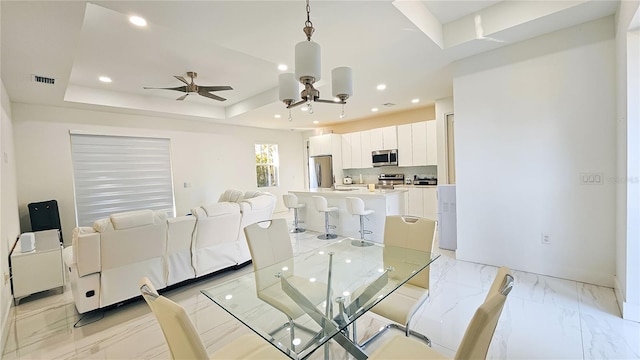 dining space featuring a raised ceiling, recessed lighting, ceiling fan, and visible vents
