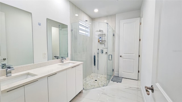 bathroom with marble finish floor, a sink, a stall shower, and double vanity