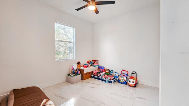 playroom with baseboards and a ceiling fan