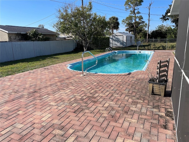 view of pool featuring a fenced backyard, a shed, an outdoor structure, and a patio