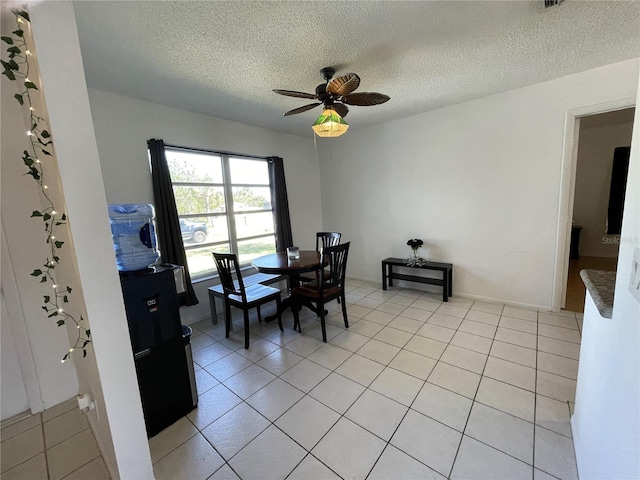 dining space featuring a textured ceiling, ceiling fan, and light tile patterned floors