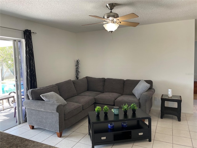 living area with a textured ceiling, light tile patterned floors, and a ceiling fan