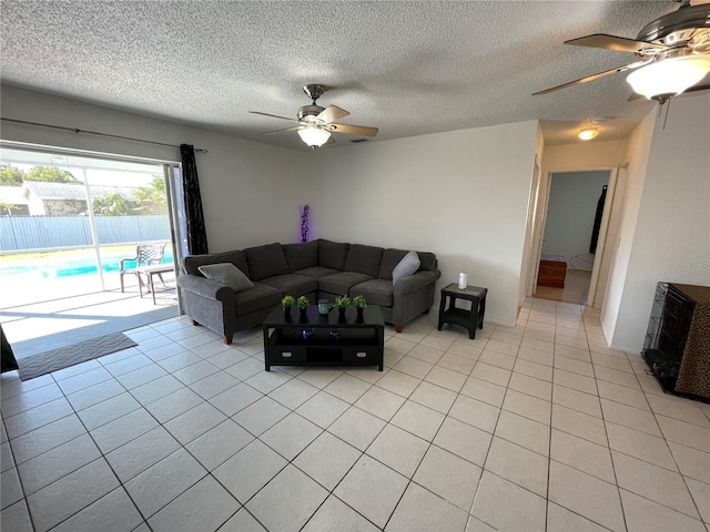 living area with light tile patterned flooring, a textured ceiling, and ceiling fan