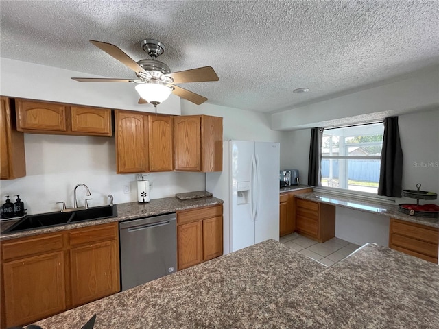 kitchen with a sink, brown cabinets, white fridge with ice dispenser, and dishwasher