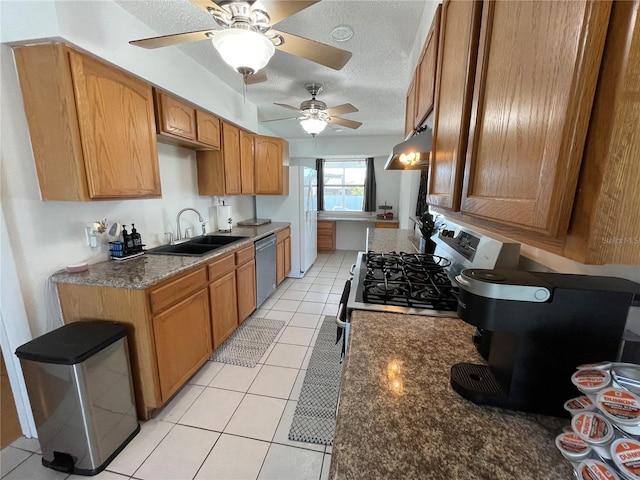 kitchen with under cabinet range hood, stainless steel dishwasher, range with gas stovetop, a sink, and a ceiling fan