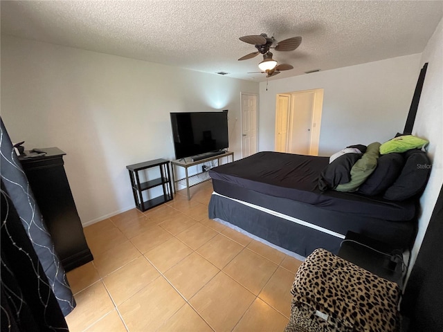 bedroom featuring light tile patterned floors, visible vents, a textured ceiling, and ceiling fan