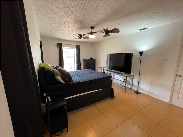 bedroom featuring a textured ceiling, visible vents, ceiling fan, and light tile patterned floors