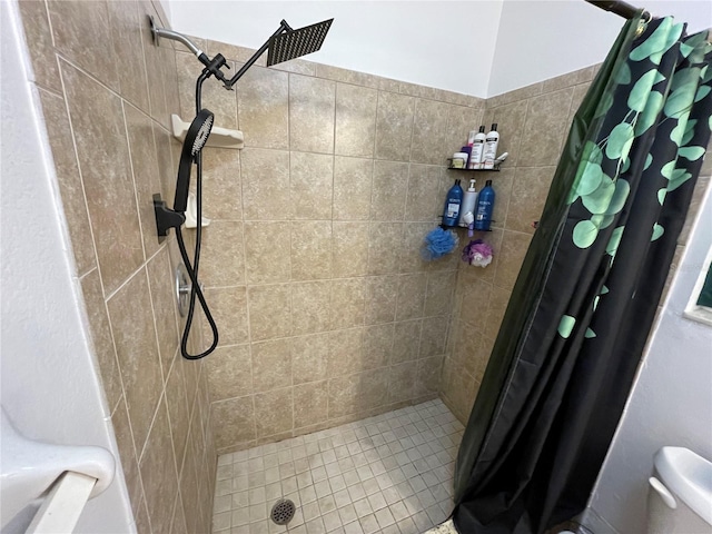 bathroom featuring toilet and tiled shower