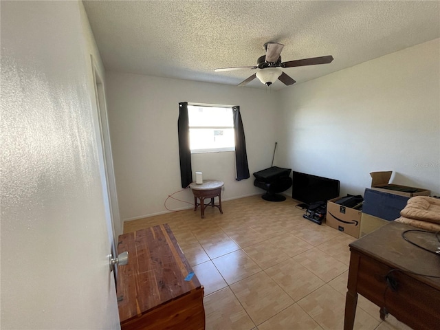 interior space with light tile patterned flooring, ceiling fan, and a textured ceiling