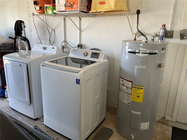 washroom featuring water heater, separate washer and dryer, and laundry area