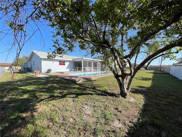 view of yard with glass enclosure, fence, and a fenced in pool