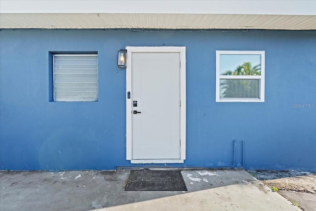 view of exterior entry with stucco siding