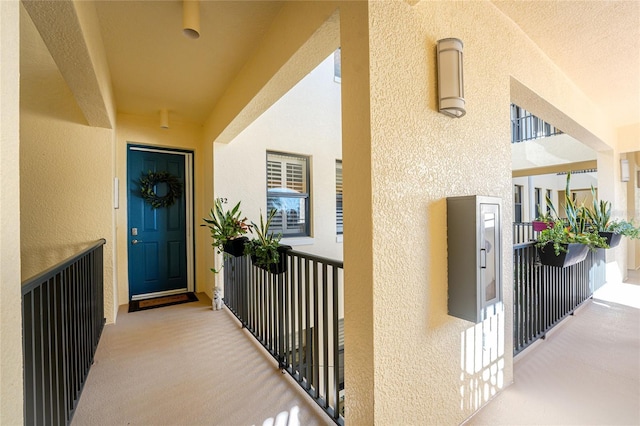entrance to property featuring a balcony and stucco siding