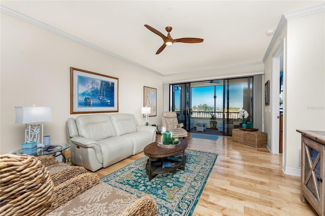 living area with crown molding, ceiling fan, and light wood-style flooring