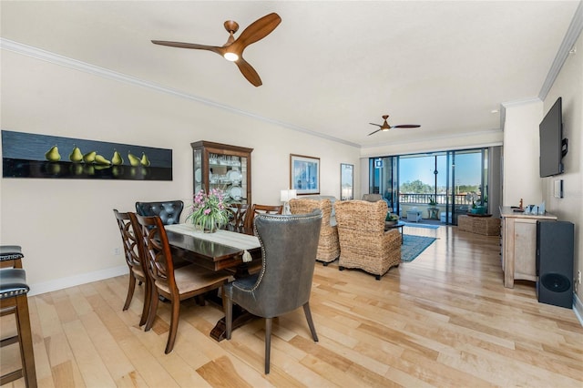 dining room with baseboards, ornamental molding, a ceiling fan, and light wood-style flooring