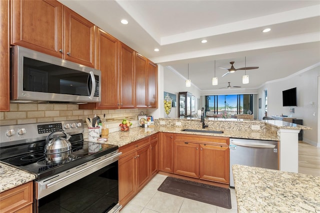 kitchen with a peninsula, open floor plan, a sink, backsplash, and stainless steel appliances