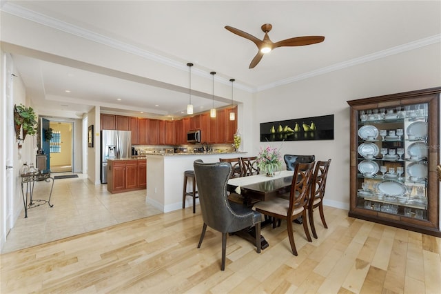dining area with crown molding, light wood-style floors, a ceiling fan, baseboards, and recessed lighting