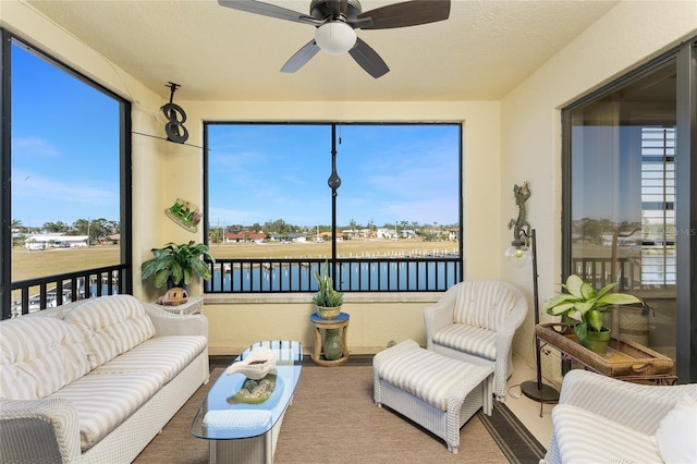 sunroom / solarium featuring plenty of natural light, a ceiling fan, and an outdoor hangout area