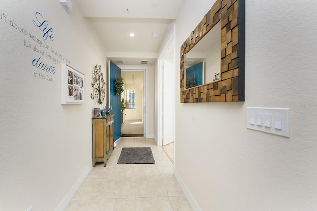 corridor featuring baseboards, recessed lighting, and light tile patterned floors