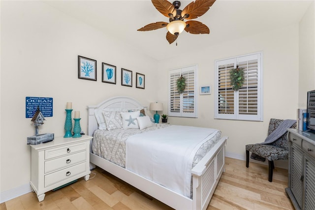 bedroom featuring baseboards, light wood-style flooring, and ceiling fan